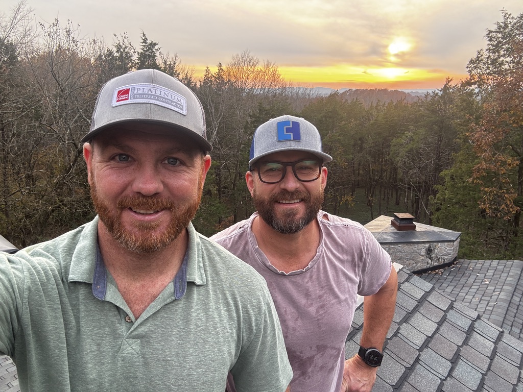 Triumph Roofing team on a roof at sunset